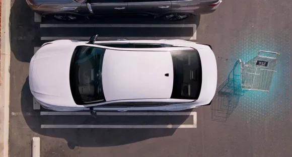Top view of a white 2027 Nissan Altima in a parking lot with rear sensors detecting a shopping cart behind it at Ricart Nissan in Groveport OH
